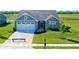 Aerial view of a blue and gray house with a yard and driveway at 6941 E Bean Blossom Dr, Camby, IN 46113