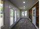 Sunroom features French doors opening to a deck, hardwood floors, and a wood accent wall at 8827 El Rico Dr, Indianapolis, IN 46240