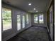 Sunroom features French doors opening to a deck, hardwood floors, and a wood accent wall at 8827 El Rico Dr, Indianapolis, IN 46240