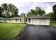 Ranch home with stone facade, attached two-car garage, and landscaped lawn at 8827 El Rico Dr, Indianapolis, IN 46240