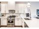 Modern kitchen with white cabinets, marble backsplash, and stainless steel appliances at 1336 Central Ave, Indianapolis, IN 46202