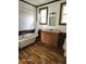 Bathroom with clawfoot tub, wood floors, and a wood vanity at 1515 S Park Ave, Alexandria, IN 46001