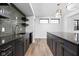 Stylish basement bar with dark cabinetry, herringbone tile, and a large island at 1328 Chatham Rdg Ct, Westfield, IN 46074