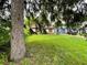 Home exterior partially obscured by trees, showcasing a grassy lawn at 3426 N Temple Ave, Indianapolis, IN 46218