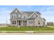 Two-story home with gray siding, stone accents, and a landscaped lawn at 15287 Garden Mist Pl, Fishers, IN 46037