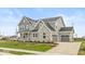 Two-story house with gray siding, stone accents, and a three-car garage at 15287 Garden Mist Pl, Fishers, IN 46037