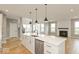 Modern kitchen with white cabinets, island, and stainless steel appliances at 15287 Garden Mist Pl, Fishers, IN 46037