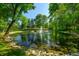 Picturesque pond with fountain, lush greenery, and reflections at 4023 Cedar Hills N Dr, Greenwood, IN 46143