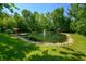 Calm pond with fountain, dock, and surrounding trees at 4023 Cedar Hills N Dr, Greenwood, IN 46143