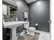 Small bathroom with white pedestal sink, toilet, and dark gray walls at 4023 Cedar Hills N Dr, Greenwood, IN 46143