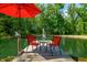 Serene pond dock with seating, umbrella, and fountain view at 4023 Cedar Hills N Dr, Greenwood, IN 46143