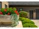 Elegant stone planter with vibrant red flowers and trailing greenery adorns the home's entrance at 4023 Cedar Hills N Dr, Greenwood, IN 46143