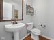 Clean bathroom with pedestal sink, toilet, and wood-look flooring at 917 Balto Dr, Shelbyville, IN 46176