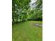 Side yard with mature trees and a fenced area at 1231 E 88Th St, Indianapolis, IN 46240