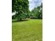 Large front yard with mature trees and a long driveway at 1231 E 88Th St, Indianapolis, IN 46240