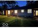 Night view of a ranch house with a stone exterior and well-maintained lawn at 1231 E 88Th St, Indianapolis, IN 46240