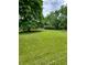 Large front yard with mature trees and a long driveway at 1231 E 88Th St, Indianapolis, IN 46240