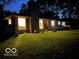 Attractive ranch home with illuminated windows and landscaped lawn at night at 1231 E 88Th St, Indianapolis, IN 46240