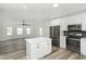 Open floor plan showing kitchen island and living room with modern ceiling fan at 22133 State Road 37 N, Noblesville, IN 46060