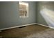 Simple bedroom with gray walls, brown carpet, and boarded window at 642 N Oxford St, Indianapolis, IN 46201