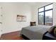 Bedroom with hardwood floors and a large window overlooking the street at 877 N East St # 104, Indianapolis, IN 46202