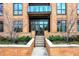 Brick building exterior with modern glass doors, leading to a private balcony at 877 N East St # 104, Indianapolis, IN 46202