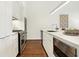 Modern white kitchen with stainless steel appliances and quartz countertops at 877 N East St # 104, Indianapolis, IN 46202