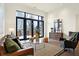 Living room with large windows, hardwood floors, and comfortable seating at 877 N East St # 104, Indianapolis, IN 46202