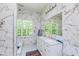 Elegant bathroom with double vanity, marble tile, and large window at 372 Foxboro Cir, Avon, IN 46123