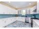 White kitchen with teal tile backsplash and stainless steel appliances at 372 Foxboro Cir, Avon, IN 46123