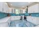 White kitchen with teal tile backsplash and stainless steel appliances at 372 Foxboro Cir, Avon, IN 46123