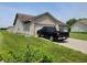 Tan brick ranch home with a black truck parked in the driveway at 1096 Bumblebee Way, Greenfield, IN 46140