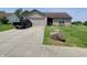 Tan brick ranch home with a black truck parked in the driveway and a large rock at 1096 Bumblebee Way, Greenfield, IN 46140