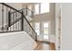 Modern staircase with black metal railing and hardwood floors at 15278 Quiet Trace Ct, Fishers, IN 46037