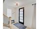 Bright entryway with a modern door and wood staircase at 1544 Hoyt Ave, Indianapolis, IN 46203