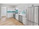 Modern kitchen with white cabinets, teal tile, and stainless steel appliances at 249 N Beville Ave, Indianapolis, IN 46201