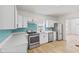 Modern kitchen with white cabinets and teal backsplash at 249 N Beville Ave, Indianapolis, IN 46201