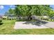 Stone house with a large tree and gravel driveway at 11445 N School St, Fishers, IN 46038