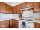 Kitchen with wood cabinets, white appliances, and a corner workstation at 9996 N County Road 200 W, Muncie, IN 47302