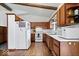 Kitchen with wood cabinets, white appliances, and hardwood floors at 9996 N County Road 200 W, Muncie, IN 47302