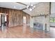 Living room with hardwood floors, stone fireplace, and wood-paneled accent wall at 9996 N County Road 200 W, Muncie, IN 47302