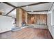 Living room with hardwood floors, stone fireplace, and wood-paneled accent wall at 9996 N County Road 200 W, Muncie, IN 47302