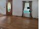Image shows a living room with hardwood floors, an oval-shaped door and floral curtains at 3526 N Capitol Ave, Indianapolis, IN 46208