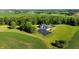 Aerial view showcasing home's rear, tennis court, and surrounding fields at 3917 N 525 W, Fairland, IN 46126