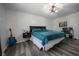 Bedroom with teal bedding, guitar, and wood-look floors at 3829 Chancellor Dr, Greenwood, IN 46143