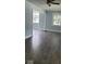 Spacious living room with light blue walls and dark gray vinyl flooring at 41 S Sherman Dr, Indianapolis, IN 46201