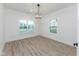 Bright bedroom with wood-look flooring, chandelier, and two windows at 706 S Main St, Whitestown, IN 46075