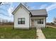 Charming white farmhouse exterior with pink door and gray metal roof at 706 S Main St, Whitestown, IN 46075