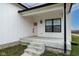 Inviting front porch with pink door and black window frames at 706 S Main St, Whitestown, IN 46075