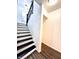 Stylish staircase with black and white painted steps and wooden railing at 3442 N Capitol Ave, Indianapolis, IN 46208